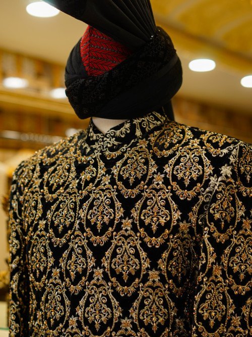 Short Sherwani in Rich Black Tone with Ornate Golden Hand Embroidery and Matching Kulla for a Regal Appeal